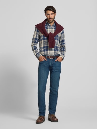Männermodel trägt Slim Fit Jeans mit Used Waschung von POLO RALPH LAUREN in Medium Wash Denim, sichtbare Nähte, 5-Pocket-Design, Ganzkörperansicht von vorne.