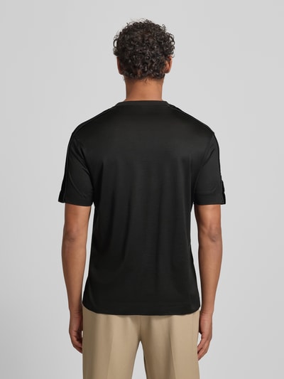 Männermodel trägt T-Shirt mit Label-Detail von Emporio Armani in Schwarz, Lyocell-Baumwoll-Mix, Regular-Fit, Rückenlänge 70 cm, Ganzkörperansicht Rückansicht.
