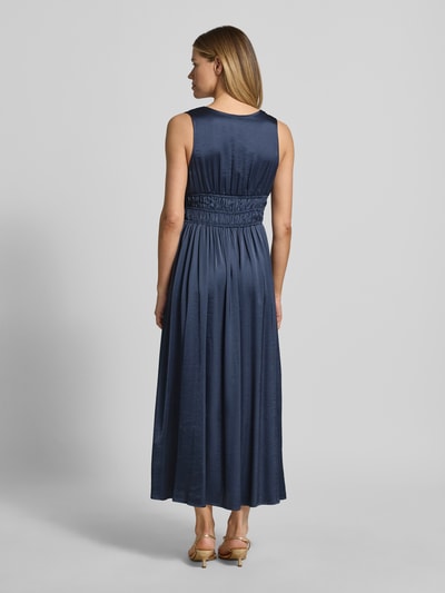 Kobieta modelka nosi długą sukienkę Maxikleid mit tiefem V-Ausschnitt model 'Marja' od mbyM, mieszanka materiałów z dodatkiem wiskozy, taliowany fason, wiązanie, długość tyłu w rozmiarze S: 130 cm, szerokość w rozmiarze S: 36 cm, widok całej sylwetki z tyłu.