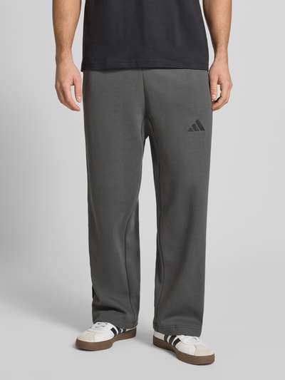 Männermodel trägt Sweatpants mit elastischem Bund und Tunnelzug von adidas Sportswear, Regular Fit, Baumwoll-Mix, Ganzkörperansicht von vorne.