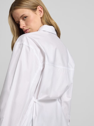 Frauenmodel trägt Oversized Hemdbluse mit Brusttasche Modell 'Demi' von Topshop aus reiner Baumwolle, weiß, Langärmelig, Nahaufnahme Rückansicht.
