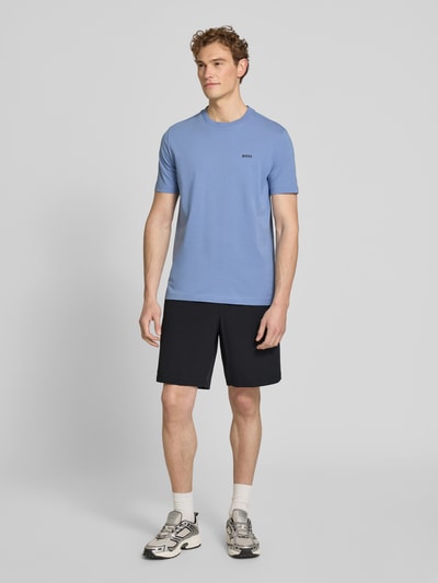 Männermodel trägt Regular Fit Sport-Shorts mit Label Print Modell 'TREVOL' von BOSS Green, schwarze 4-way Stretch-Shorts, seitliche Taschen, Tunnelzugbund, Ganzkörperansicht von vorne.