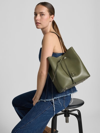 Kobiece model prezentuje Henkeltasche mit Kordel od BOSS, zielony kolor, widoczna faktura skóry, detal metalowy, widok z boku, Nahaufnahme Oberkörper.