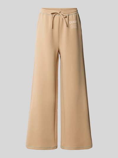 Produktfoto, beige Wide Fit Sweatpants aus Baumwoll-Mix Modell 'Gunda' von GUIDO MARIA KRETSCHMER WOMAN mit Tunnelzugbund und Logo-Print.