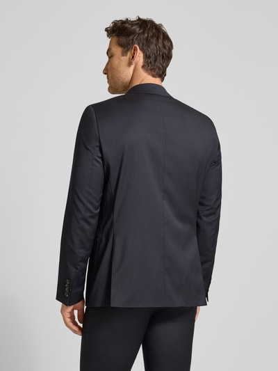 Männermodel trägt Slim Fit 2-Knopf-Sakko mit Pattentaschen Modell 'Move Alesso' von DIGEL in Dunkelblau, Rückansicht Ganzkörperansicht. Schurwoll-Elasthan-Mix, Reverskragen, Rückenlänge 74 cm, Schulterbreite 46 cm, Ärmellänge 67 cm.