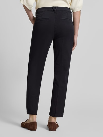Frauenmodel trägt Chino mit Eingrifftaschen von MAC in Dunkelblau, Baumwoll-Elasthan-Mix, Regular Fit, Gesäßtaschen, Ganzkörperansicht Rückansicht.