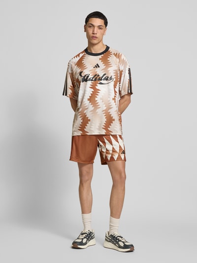 Mannenmodel draagt Regular Fit Sweatshorts met all-over motief van adidas Sportswear, look: all-over motief, regular fit, labelprint, elastische boord, zij-steekzakken, productfoto, adidas Sportswear. Ganzkörperansicht von vorne.