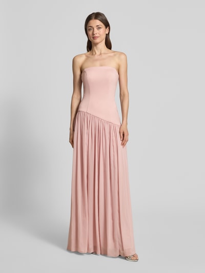 Frauenmodel trägt Abendkleid in Falten-Optik von Unique in Rosé, taillierte Passform, asymmetrisches Design, Maxilänge, Schulterfrei, Ganzkörperansicht von vorne. Rückenlänge bei Größe 36: 133 cm, Brustweite bei Größe 36: 37 cm.