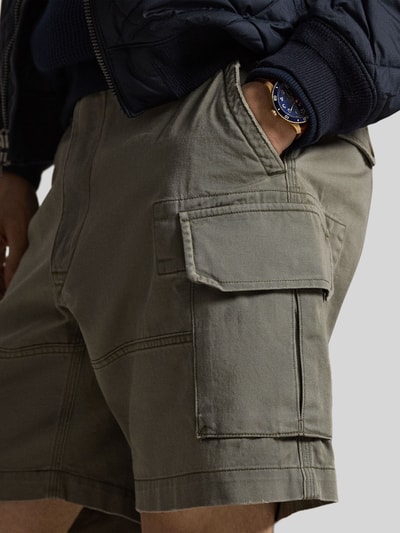 Männermodel trägt Relaxed Fit Cargoshorts aus reiner Baumwolle von Polo Ralph Lauren in Optik: Unifarben mit Logo-Stitching, Nahaufnahme Oberkörper.