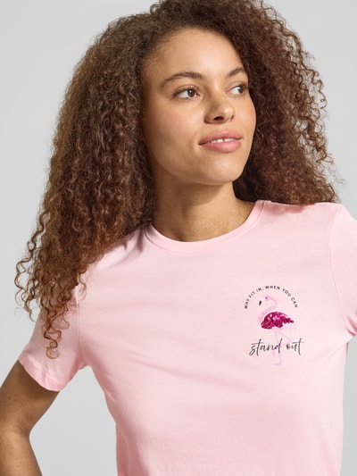 Frauenmodel trägt Damen T-Shirt Regular Fit T-Shirt aus reiner Baumwolle Modell 'KITA' von Only, Optik: Unifarben, Motiv-Print und Pailletten, Rundhals, Kurzarm, Materialverarbeitung: Jersey, Material: reine Baumwolle, Nahaufnahme Oberkörper.