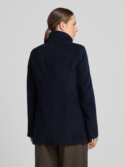 Frauenmodel trägt Jacke mit Stehkragen und Eingrifftaschen von FUCHS SCHMITT, mieszanka materiałów z dodatkiem wełny, Linia a, listwa guzikowa, wpuszczane kieszenie, długość tyłu w rozmiarze 36: 73 cm, szerokość ramion w rozmiarze 36: 37 cm, szerokość w klatce piersiowej w rozmiarze 36: 48 cm, długość rękawów w rozmiarze 36: 64 cm, granatowy kolor, miękka tekstura, widok całego ciała z tyłu.