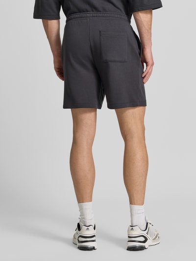 Männermodel trägt Straight Fit Shorts mit Logo-Stitching Modell 'Arch' von GAP in Dunkelgrau, Baumwoll-Mix, Ganzkörperansicht Rückansicht.