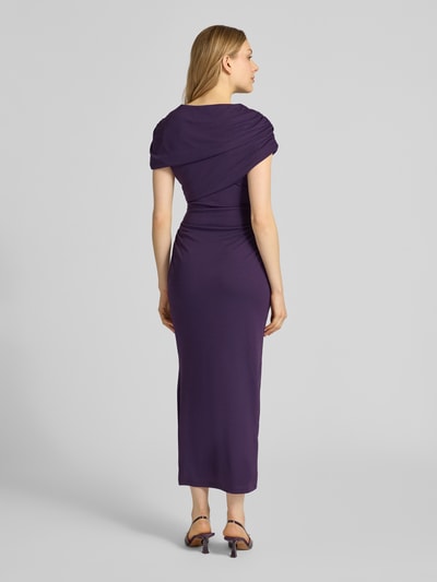 Männermodel trägt figurbetontes lilafarbenes Midikleid mit Drapierungen, Modell 'Kori Draped' von Forever New, Ganzkörperansicht Rückansicht, długość tyłu w rozmiarze 36: 137 cm, szerokość w rozmiarze 36: 42 cm, długość rękawa w rozmiarze 36: 23 cm.