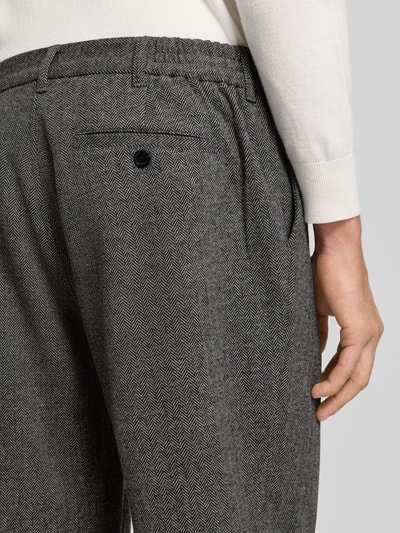 Mężczyzna nosi spodnie z zakładkami w pasie Bundfaltenhose mit Gesäßtaschen Modell 'hector' od Matinique, Mieszanka materiałów z mieszanką bawełny, krój regular fit, elastyczny pas, kieszenie z tyłu, Szerokość w rozmiarze 32/32: 41 cm, Długość wewnętrzna nogawki: 81 cm, zbliżenie na tył.