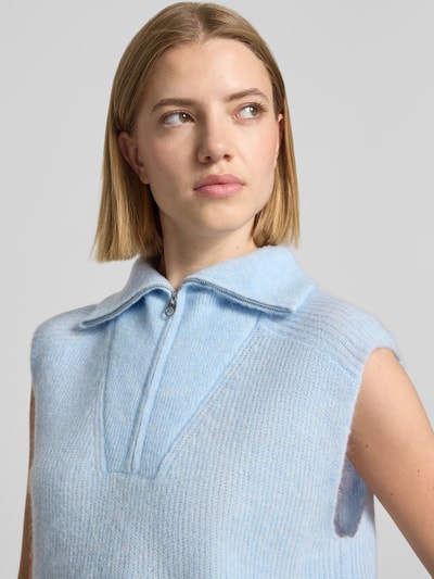 Frauenmodel trägt Pullunder aus Alpaka-Mix mit Stehkragen Modell 'Thora' von MOS MOSH, hellblau, softer Strick, Nahaufnahme Oberkörper, Damen Pullunder, Regular Fit mit Reißverschluss, Lanawoll-Anteil.