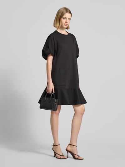 Frauenmodel trägt knielanges Tunika-Kleid mit Puffärmeln Modell 'ONORE' von Max Mara, Schwarz, A-Linie, Baumwoll-Mix, Ganzkörperansicht von vorne.