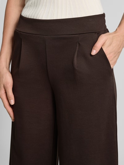 Frauenmodel trägt Hose mit weitem Bein Modell 'KATE' von ICHI, unifarbenes Braun, elastischer Bund, Material-Mix, Nahaufnahme Oberkörper.