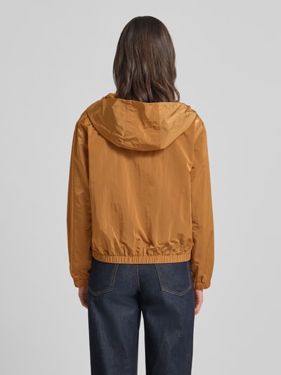 Männermodel trägt Trekking Jacke mit Kapuze und Reißverschlusstaschen von Rich & Royal w kolorze karmelowym, prosty krój, kaptur z trokiem, zamek błyskawiczny, boczne kieszenie zapinane na zamek błyskawiczny, elastyczne wykończenia, długość tyłu w rozmiarze 36: 58 cm, szerokość ramion w rozmiarze 36: 48 cm, szerokość klatki piersiowej w rozmiarze 36: 56 cm, długość rękawów w rozmiarze 36: 59 cm, tekstura gładka, Ganzkörperansicht Rückansicht