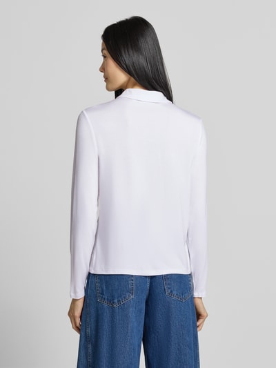 Frauenmodel trägt Slim Fit Hemdbluse aus Viskose-Mix von COMMA in Weiß mit Hemdblusenkragen und langen Ärmeln, Ganzkörperansicht Rückansicht.
