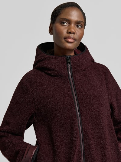 Kobiece modelka nosi Regular Fit Jacke mit Kapuze od FUCHS SCHMITT, Futerko, bordowy kolor, zamek błyskawiczny dwustronny, z kapturem, Szerokość ramion w rozmiarze 36: 41 cm, Szerokość klatki piersiowej w rozmiarze 36: 48 cm, Długość rękawów w rozmiarze 36: 62 cm, Długość tyłu w rozmiarze 36: 57 cm, zbliżenie na górną część ciała.