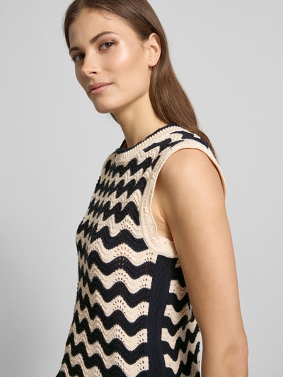 Frauenmodel trägt Pullunder im Allover-Look mit Wellensaum von Christian Berg Woman, creme und schwarz, Rundhalsausschnitt, Nahaufnahme Oberkörper.