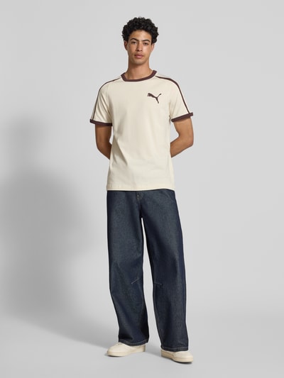 Männermodel trägt Regular Fit T-Shirt mit Logo-Print von PUMA PERFORMANCE in Cremebraun, reine Baumwolle, Rundhalsausschnitt, Ganzkörperansicht von vorne.