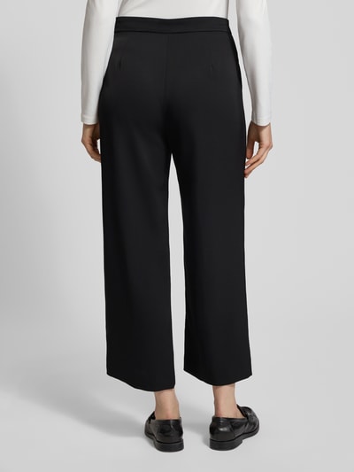 Frauenmodel trägt Culotte mit Längsnähten Modell 'PALINA' von Raffaello Rossi in Schwarz mit weitem Bein, verkürzte Passform, Ganzkörperansicht Rückansicht.