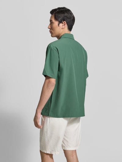 Männermodel trägt Regular Fit Freizeithemd mit Reverskragen von MCNEAL in Grün, Material-Mix mit Stretch-Anteil, fein strukturiert, Knopfleiste, Rückenlänge bei Größe M 72 cm, Schulterbreite 49 cm, Ärmellänge 26 cm, Ganzkörperansicht Rückansicht.