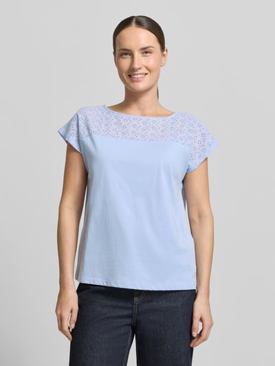 Frauenmodel trägt Regular Fit Blusentop aus reiner Baumwolle Modell 'JANNI' von Vero Moda in Hellblau, unifarben, semitransparenter Besatz, U-Boot-Ausschnitt, kurzarm, Jersey-Textur; Ganzkörperansicht von vorne.