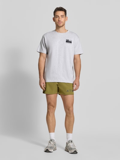 Männermodel trägt T-Shirt mit Motiv-Print und Rundhalsausschnitt von HALO aus reiner Baumwolle, Regular Fit, hellgrau, Ganzkörperansicht von vorne.