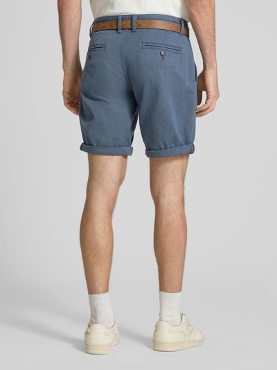 Männermodel trägt Bermudas mit Gürtel und Eingrifftaschen Modell 'NEBRASKA' von Redefined Rebel in blauem Baumwoll-Mix mit Stretch-Anteil, Straight Fit, Knopf- und Reißverschluss, Bundweite bei Größe L 46 cm, Innenbeinlänge 21 cm, Ganzkörperansicht Rückansicht.