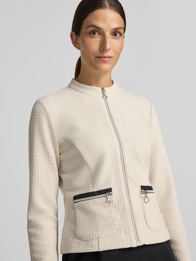 Frauenmodel trägt Regular Fit Kurzblazer mit Viskose-Anteil Modell 'NOS JULI' von Betty Barclay in Creme mit strukturierter Oberfläche, Nahaufnahme Oberkörper, Damen Kurzblazer von Betty Barclay.