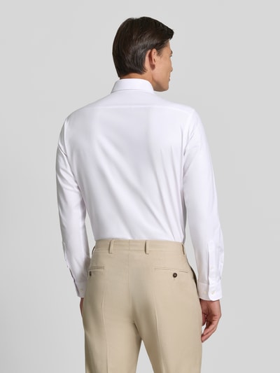Männermodel trägt Regular Fit Business-Hemd mit Kentkragen von Christian Berg Men, weiß, glatte Struktur, Rückansicht, Ganzkörperansicht Rückansicht. Baumwoll-Mix mit Stretch-Anteil, abgerundeter Saum, Rückenlänge 80 cm, Schulterbreite 48 cm, Ärmellänge 65 cm.