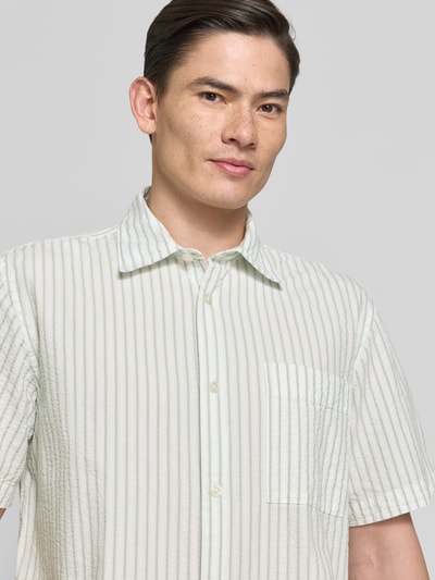 Männermodel trägt Relaxed Fit Freizeithemd aus reiner Baumwolle Modell 'STUART' von SELECTED HOMME, gestreift, Nahaufnahme Oberkörper.