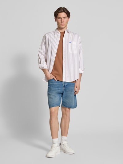 Männermodel trägt Loose Fit Jeansshorts mit Eingrifftaschen Modell 'TONY' von Jack & Jones, Reine Baumwolle, Used-Look, Ganzkörperansicht von vorne.