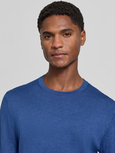 Männermodel trägt Strickpullover mit geripptem Rundhalsausschnitt von MCNEAL in Blau, taillierte Passform, Nahaufnahme Oberkörper.