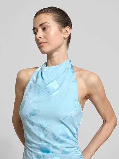 Frauenmodel trägt Neckholder-Maxikleid Modell 'della' von Forever New in Hellblau mit floraler Struktur, Material-Mix mit Viskose-Anteil, Nahaufnahme Oberkörper.