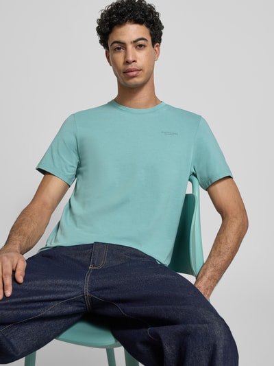 Männermodel trägt Slim Fit T-Shirt mit Logo-Stitching von G-Star Raw in Hellblau, elastischer Baumwoll-Mix, Nahaufnahme Oberkörper.