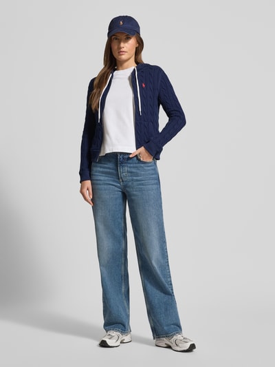 Vrouwenmodel draagt Regular Fit gebreid jack met ritssluiting van Polo Ralph Lauren, puur katoen, capuchon, tunnelkoord, steekzakken, ribboorden, labelstitching, donkerblauw met witte details, regular fit, voorkant volledig zichtbaar, Ganzkörperansicht van voren.
