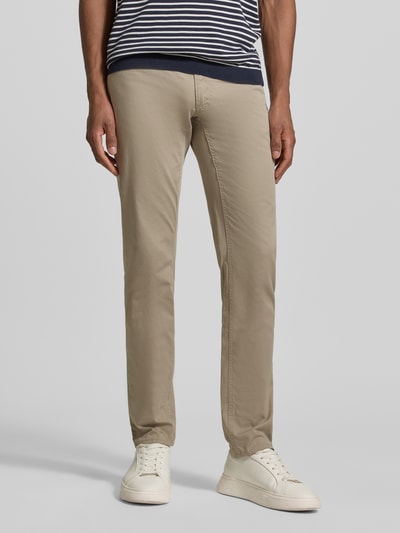 Męski model nosi Hose mit Eingrifftaschen Modell 'Chuck' von Brax, bawełniany miks z lyocellem, krój slim fit, kolor beżowy, szerokość w rozmiarze 32/32: 43 cm, długość nogawki wewnętrznej 81 cm, zdjęcie z przodu, ujęcie całej sylwetki.