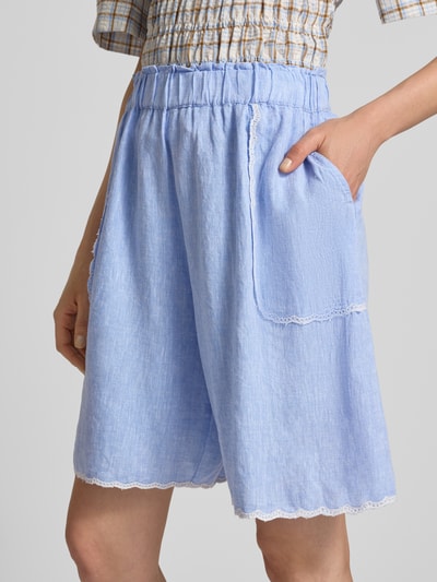 Vrouwenmodel draagt Bermudas met Leinen-Anteil und Kontrastkanten van Christian Berg Woman, lichtblauw, Viscosemix met linnen, loose fit, elastische band, contrasterende randen, bandwijdte maat 36 37 cm, binnenbeenlengte maat 36 21 cm, detailopname.
