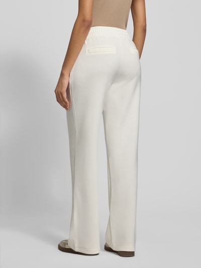 Kobiece modelka nosi Sweatpants mit elastischem Bund od Christian Berg Woman, jasny kolor, luźny krój, widoczne kieszenie, widok z tyłu, Ganzkörperansicht Rückansicht.
