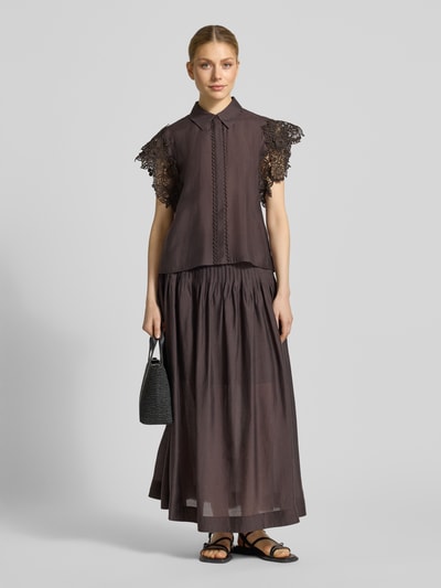 Frauenmodel trägt Regular Fit Bluse mit Spitzenbesatz Modell 'MOLLY' von Copenhagen Muse aus Material-Mix mit Stretch-Anteil, dunkler Farbton, Hemdblusenkragen, verdeckte Knopfleiste, kombiniert mit langer dunkler Rock, strukturierte Oberfläche. Ganzkörperansicht von vorne.
