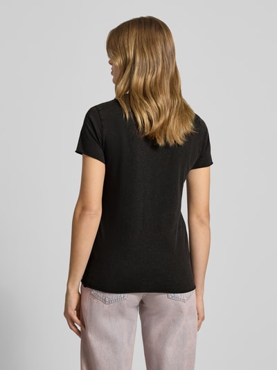 Kobiece model prezentuje Damski t-shirt Regular Fit T-Shirt aus reiner Baumwolle Modell 'LUCY' od ONLY, jednokolorowy czarny, nadruk z motywem, okrągły dekolt, krótki rękaw, zakończenia zrolowane, materiał dżersej z bawełny, widok całej sylwetki z tyłu.