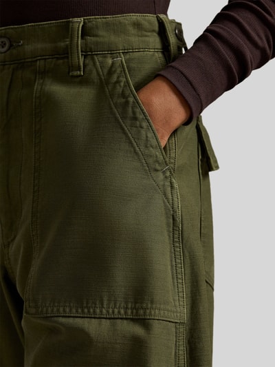 Modelka nosi Tapered Stoffhose aus reiner Baumwolle od Polo Ralph Lauren, gładka, kolor oliwkowy, wysoki stan, bawełna, krój tapered, zbliżenie na talię