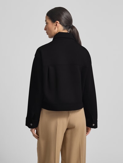 Frauenmodel trägt Jacke mit Umlegekragen Modell 'Jenima' von OPUS in Schwarz, Material-Mix, dezente Struktur, Ganzkörperansicht Rückansicht.