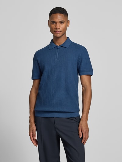 Männermodel trägt Poloshirt mit kurzem Reißverschluss und Polokragen von MCNEAL aus Reine Bio-Baumwolle, Body Fit, Ganzkörperansicht von vorne.