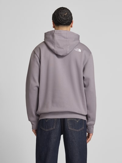 Männermodel trägt Regular Fit Hoodie mit Logo-Print von The North Face aus Baumwoll-Mix in Grau mit Kapuze, Känguru-Tasche, Rückansicht.
