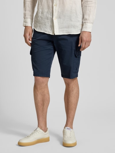Männermodel trägt Bermudas mit Cargotaschen von bugatti in Dunkelblau, Regular-Fit, Knopfverschluss, Gesäßtaschen, Ganzkörperansicht von vorne. Bundweite 45 cm, Innenbeinlänge 30 cm bei Größe 50.