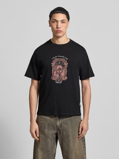 Männermodel trägt schwarzes Herren T-Shirt mit Label-Print Modell 'NIAGARA' von JACK & JONES aus Reiner Baumwolle, Gerader-Schnitt, Rundhalsausschnitt, Rückenlänge bei Größe M 67 cm, Ganzkörperansicht von vorne.